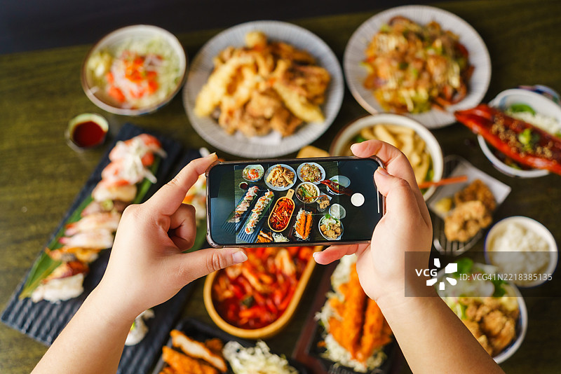 用智能手机拍摄平铺的菜肴。图片素材