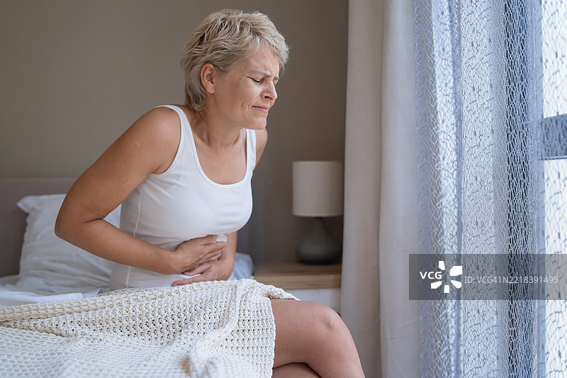 床上表情痛苦的忧伤女性图片素材