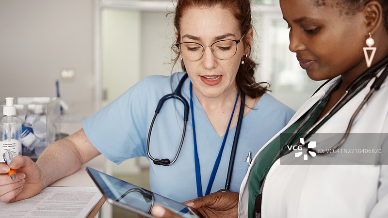 医疗工作者在诊所一起查看数字平板上的X光片图片素材