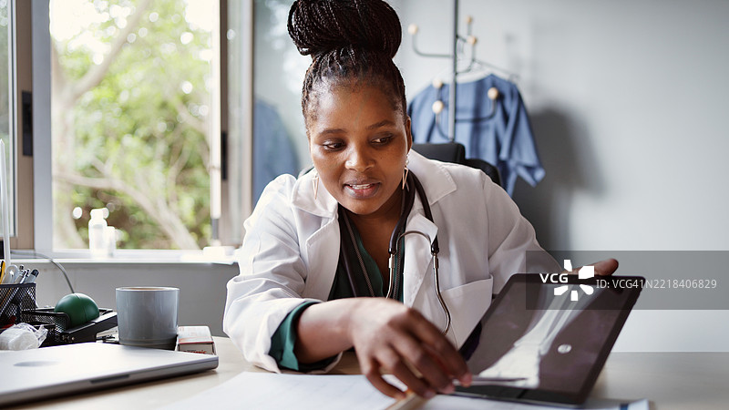 非洲女性医生在咨询期间用平板电脑解释脚部X光片图片素材