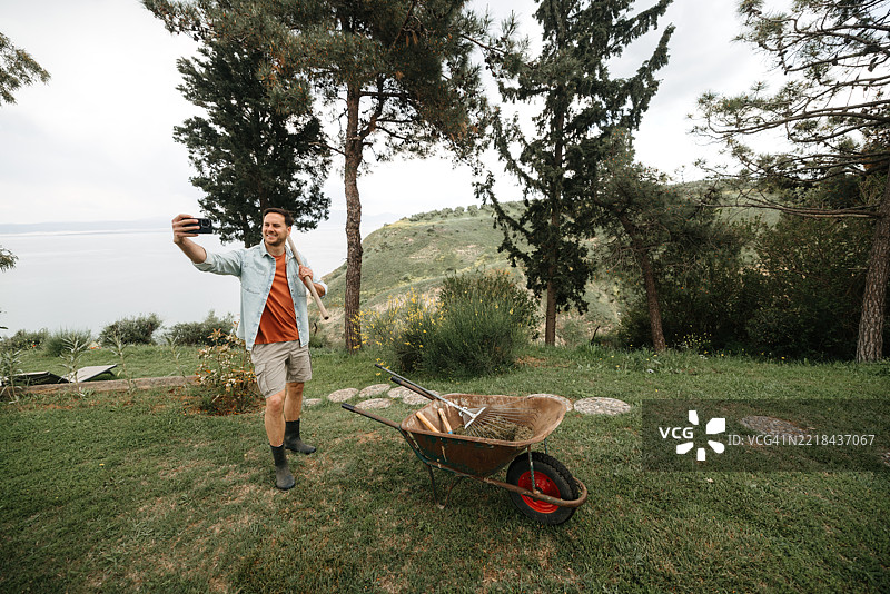 男子在后院靠近手推车自拍图片素材