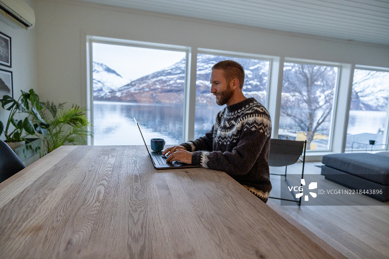 在风景如画的小屋里工作的人使用笔记本电脑图片素材