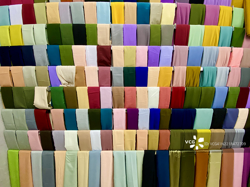 各种颜色的头巾布料整齐地排列在展示墙上图片素材