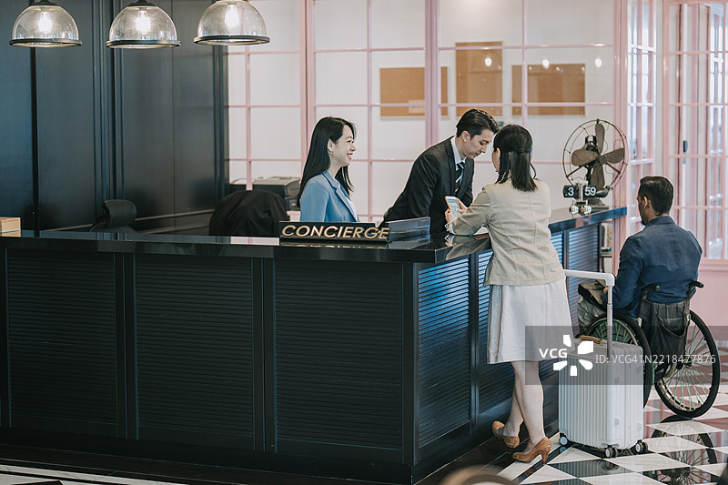 酒店礼宾团队在前台协助多样化的客人图片素材