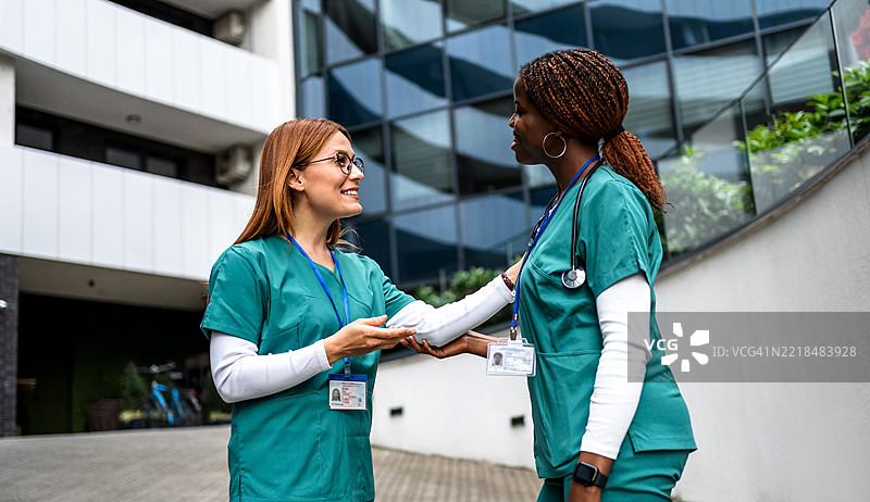 两名护士在医院外互相问候图片素材