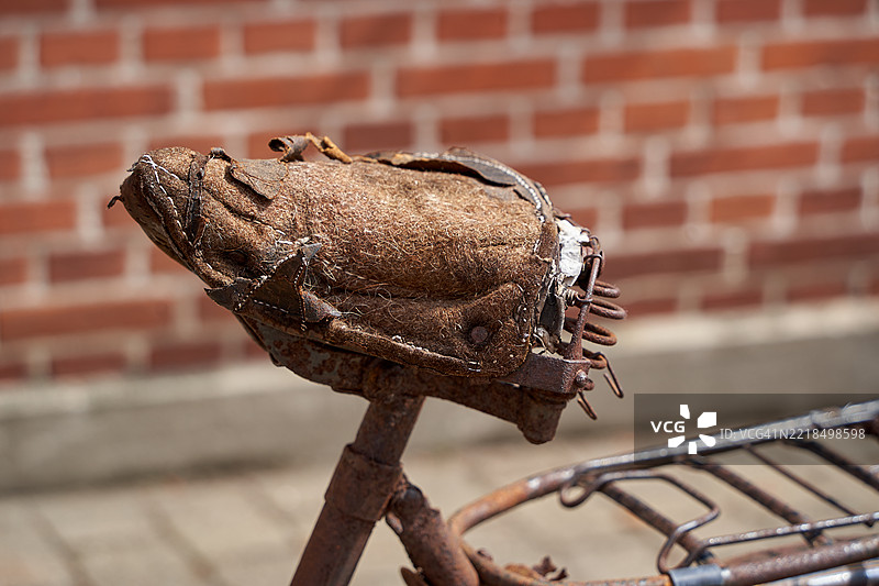 一辆非常旧的生锈自行车，座椅坏了。图片素材