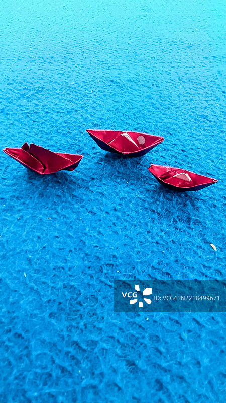 三只红色纸船在蓝色表面上，印度尼西亚塞朗巴鲁区图片素材