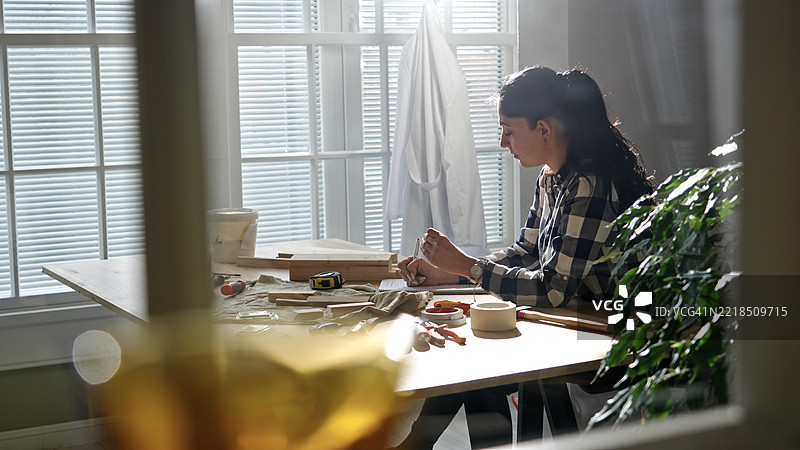 Z世代女性工匠在工作室中进行定制手工项目图片素材