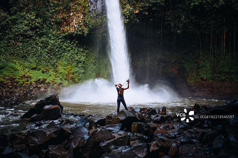 捕捉自然 – 在哥斯达黎加之旅中，女性在标志性的拉福图纳瀑布前图片素材