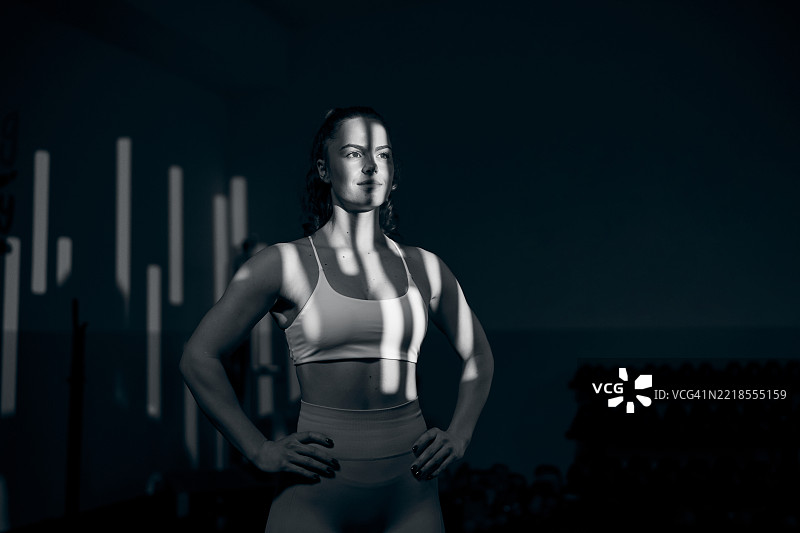 一幅黑白肖像展示了一位强壮、运动的女性在健身房。图片素材