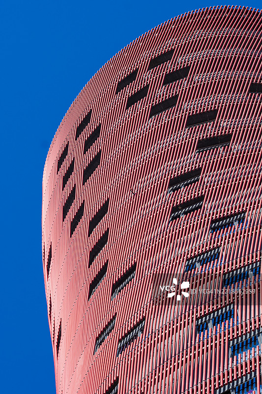 曲线红色外立面的波尔塔菲拉酒店，配有抽象窗户图案图片素材