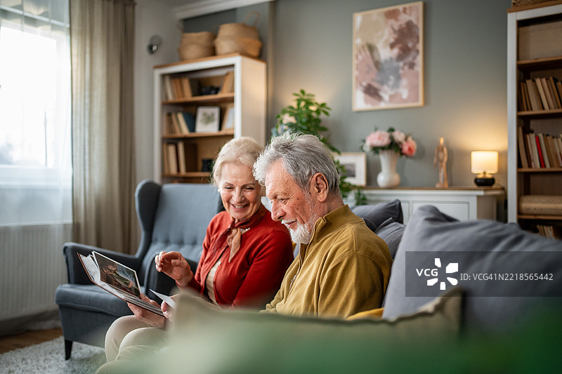 快乐的老年夫妇在家微笑着分享回忆图片素材