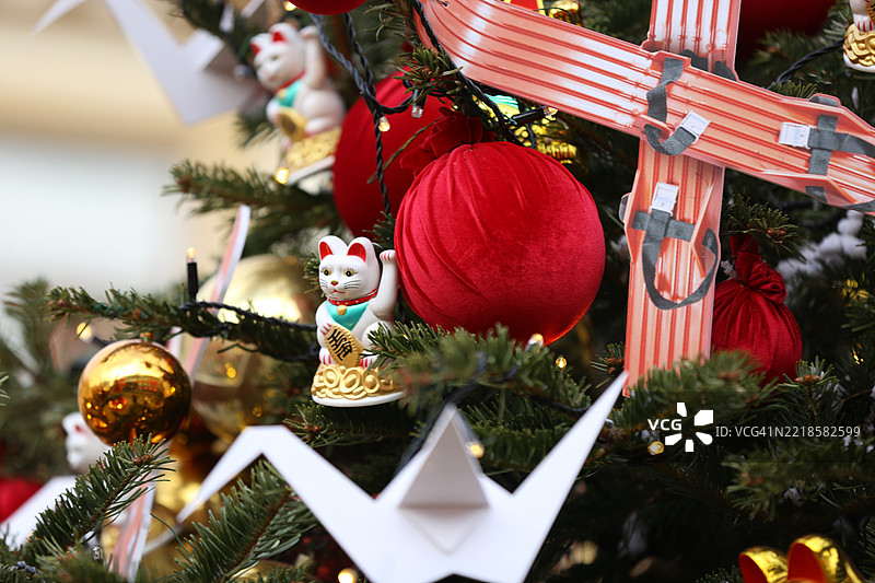 户外春节。招财猫与纸鹤和节日装饰的圣诞树图片素材