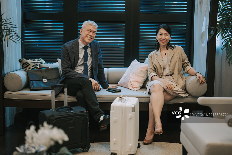 亚洲商务旅客在酒店休息室放松，微笑着看向镜头图片素材
