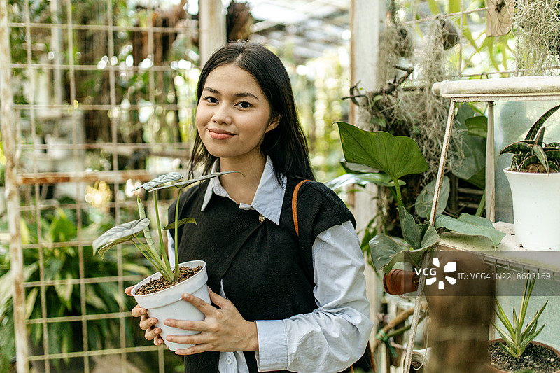 一位年轻女性在苗圃购买植物图片素材