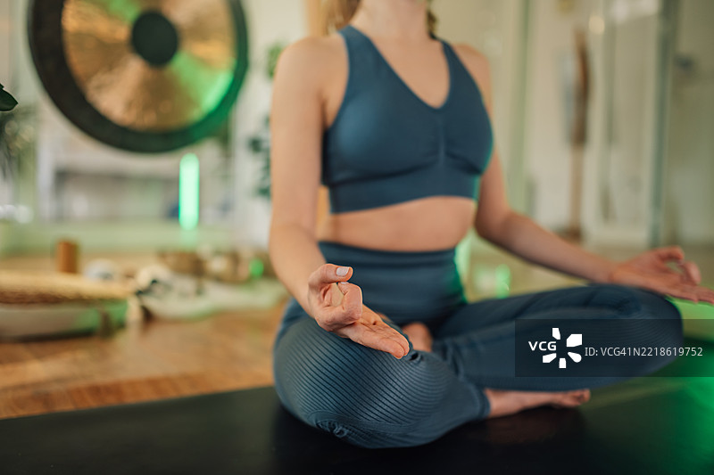 年轻女性在家中以莲花坐姿冥想图片素材