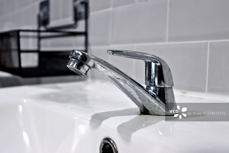 豪华设计的洗手水龙头，安装在洗手盆上。图片素材