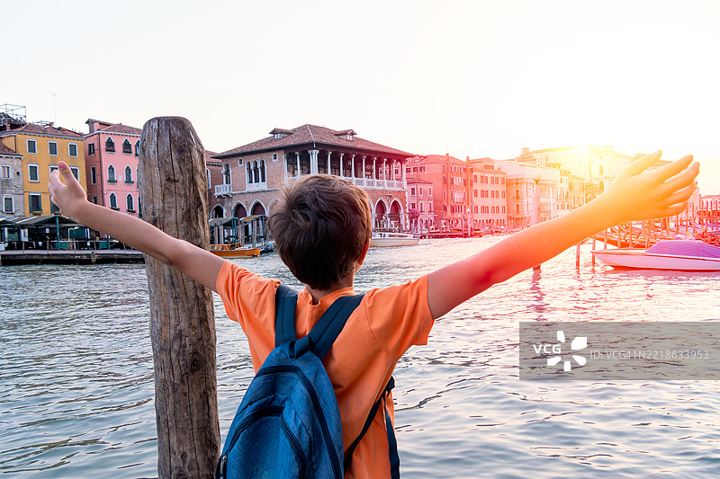 背着背包的快乐男孩俯瞰威尼斯运河图片素材