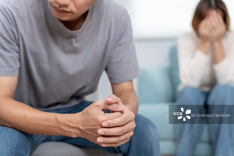 离婚的亚洲夫妇在婚后感到绝望和失望，夫妻俩都很伤心。图片素材