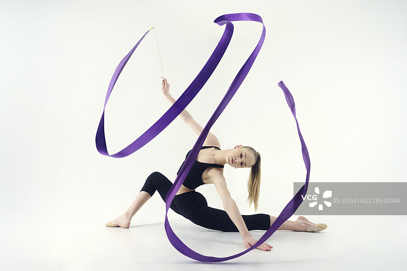 年轻的体操运动员在摄影工作室展示用彩带进行的动作，做拉伸和旋转，位于俄罗斯西伯利亚的诺沃西比尔斯克。图片素材