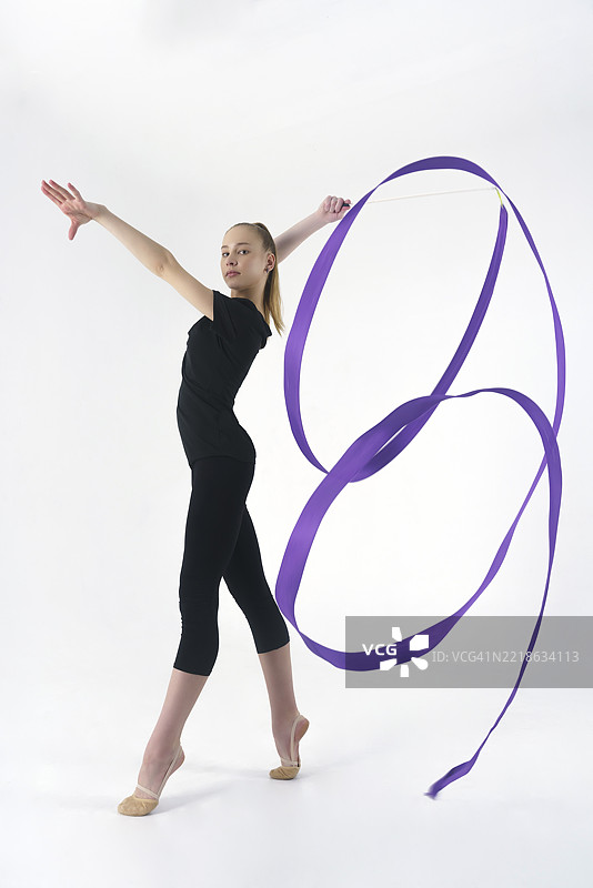 年轻的体操运动员在摄影工作室展示用彩带进行的动作，做拉伸和旋转，位于俄罗斯西伯利亚的诺夫西比尔斯克。图片素材