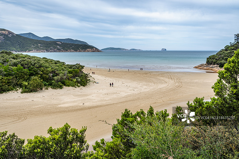 海岸沙滩场景，人们，沙子，以及威尔逊岬潮汐河的树木图片素材