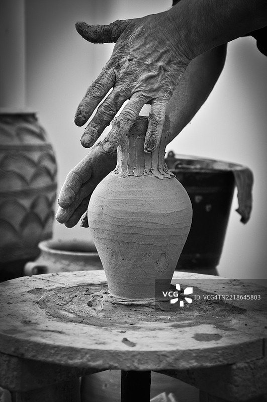 陶艺师在桌子上制作陶罐的手部特写图片素材