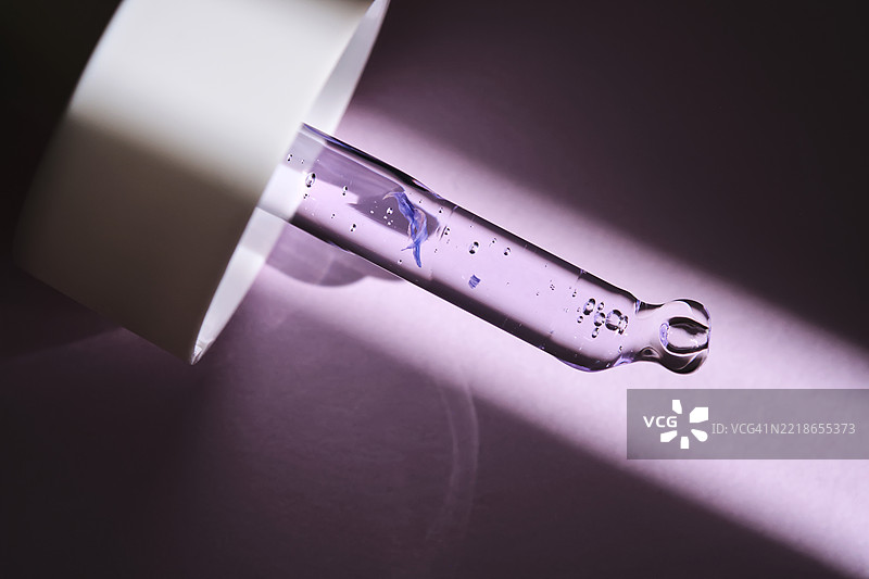 紫色背景下阳光照射下的带血清的移液管图片素材