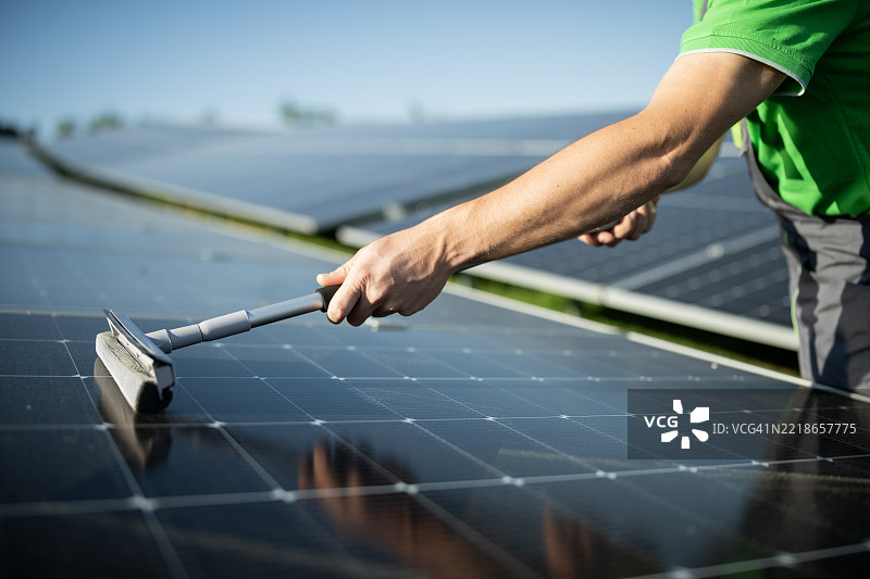 工人清洁光伏面板系统的特写镜头。图片素材