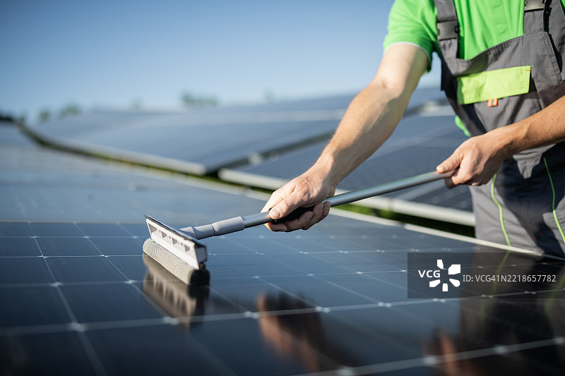 工人清洁光伏面板系统的特写镜头。图片素材