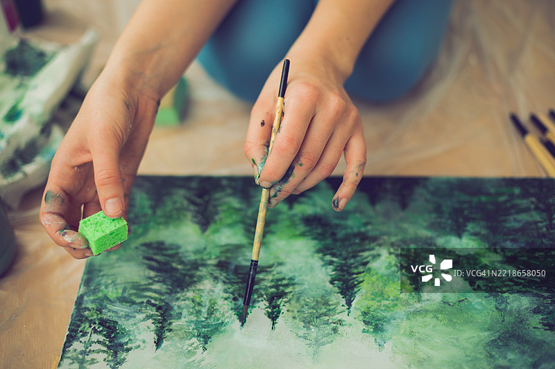 女性在桌子上绘画的中段图片素材