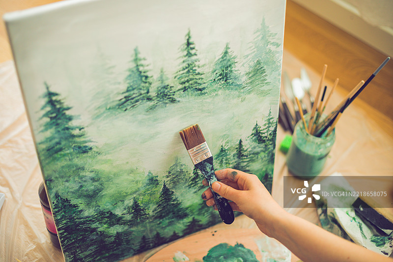 女人在桌子上绘画的手部特写图片素材