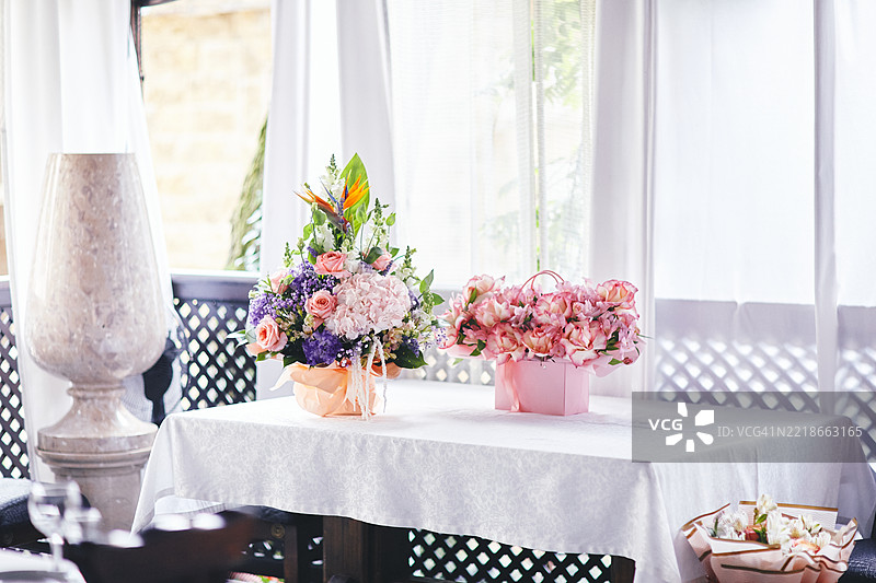 阳光明媚的室内环境中的优雅花卉摆设图片素材