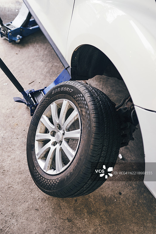 汽车维护场景，展示抬高的车辆和轮胎更换图片素材