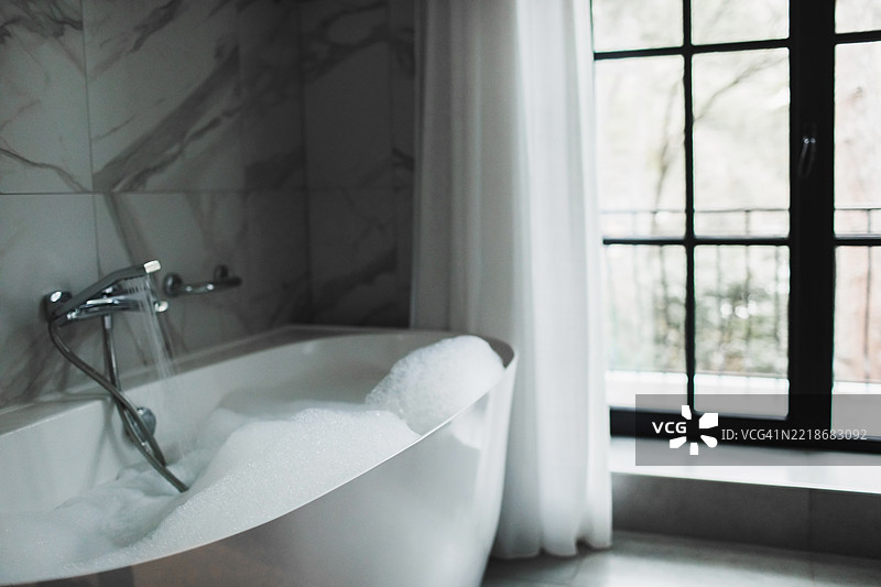 奢华浴室，配有大窗户和自然光的浴缸图片素材