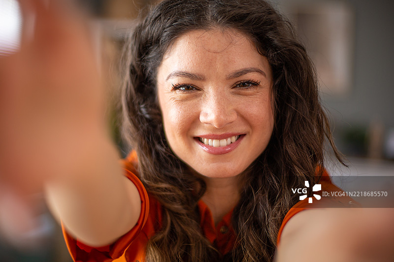 年轻女性在自拍并伸手向相机。图片素材