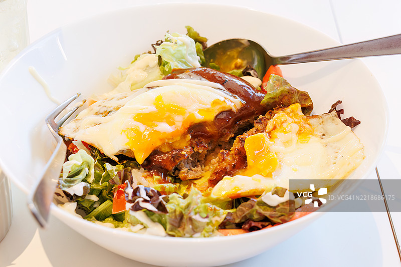 假日里的厨房车。时尚咖啡馆里的洛可莫可碗。汉堡牛排和煎蛋放在米饭上，淋上肉汁。美味。图片素材