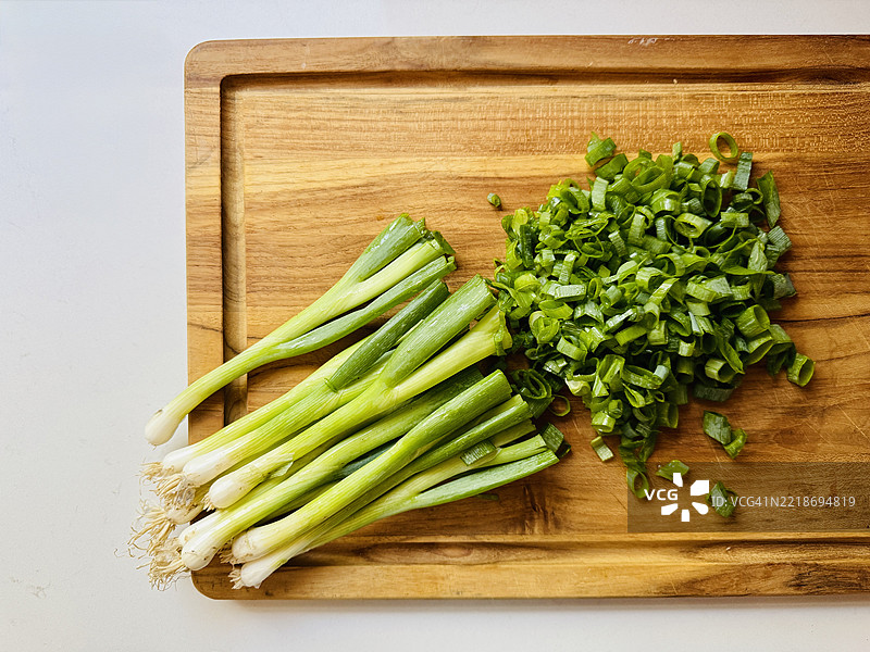 切好的青葱和葱杆放在砧板上图片素材