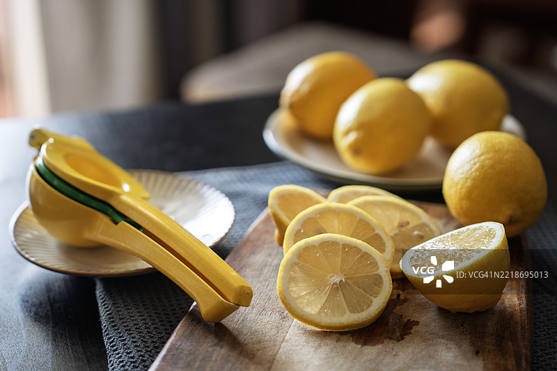 切片柠檬和手动榨汁机放在厨房台面上图片素材