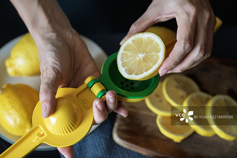 新鲜柠檬被放入手动榨汁机中图片素材