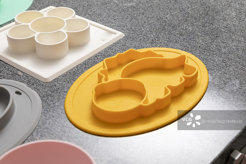 五颜六色的硅胶婴儿餐具放在厨房台面上图片素材