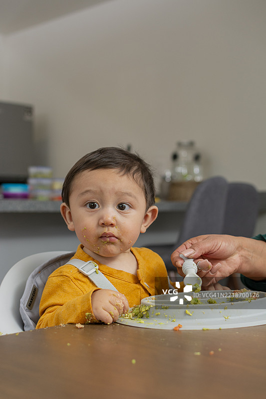 宝宝在家用勺子吃泥状食物图片素材