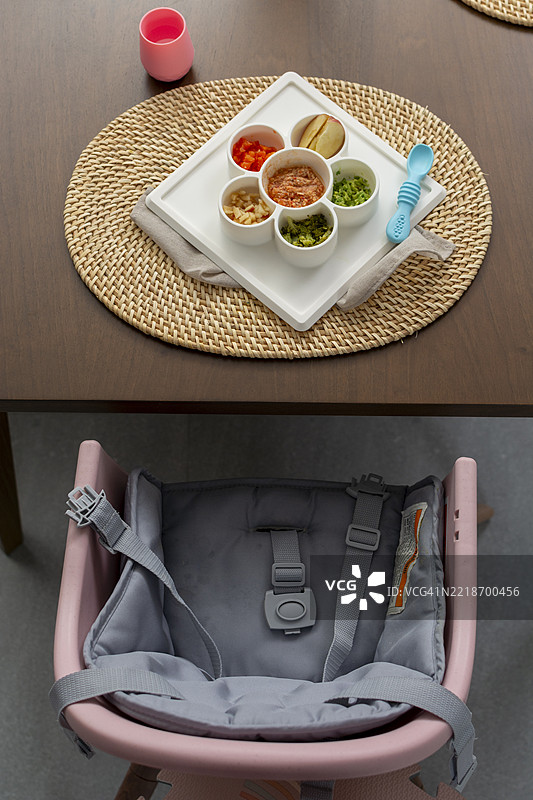 婴儿食品放在盘子里，婴儿椅上等待宝宝。图片素材