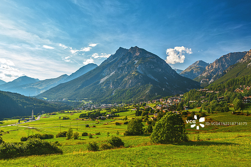 意大利的风景 - 博尔米奥阿尔卑斯村庄坐落在高耸山脉下的绿色山谷中图片素材