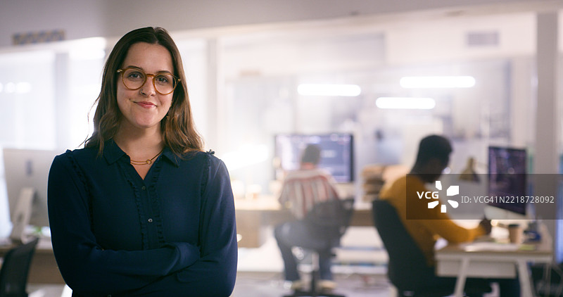 自信的女性在现代办公室环境中与专注于技术和软件开发的同事们一起工作图片素材