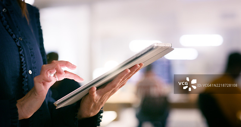 女性专业人士在协作办公环境中使用数字平板的特写镜头图片素材