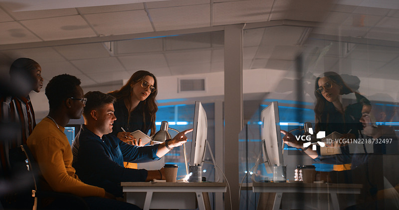 团队在深夜办公室会议中协作，使用科技工具图片素材