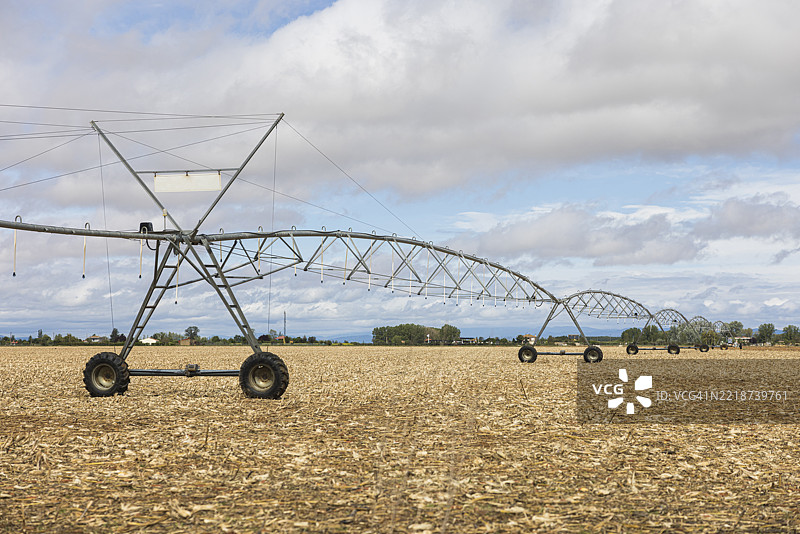 宽角镜头拍摄的中心枢轴灌溉系统，位于已收获的农村农田上。农业灌溉系统，现代农业，乡村风景，水资源管理，已收获的田地，可持续发展。图片素材