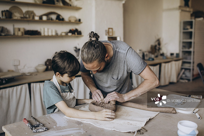 陶艺师在他的工作室教男孩图片素材