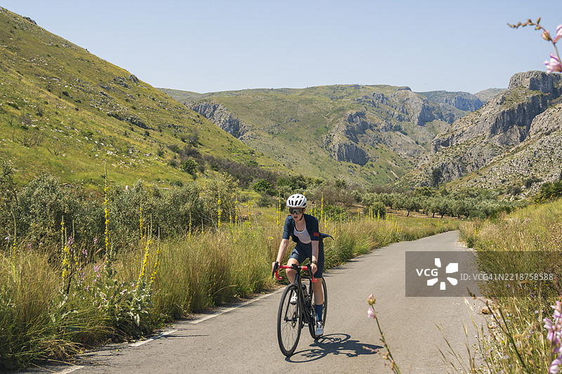 西班牙山区攀爬中的年轻少女骑自行车的景象图片素材